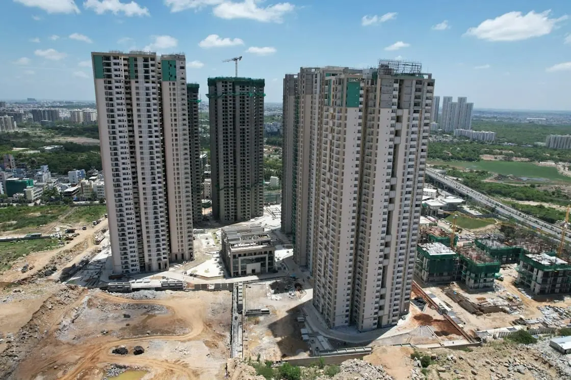 Vista aérea de varias torres de viviendas en construcción rodeadas de solares y obras.