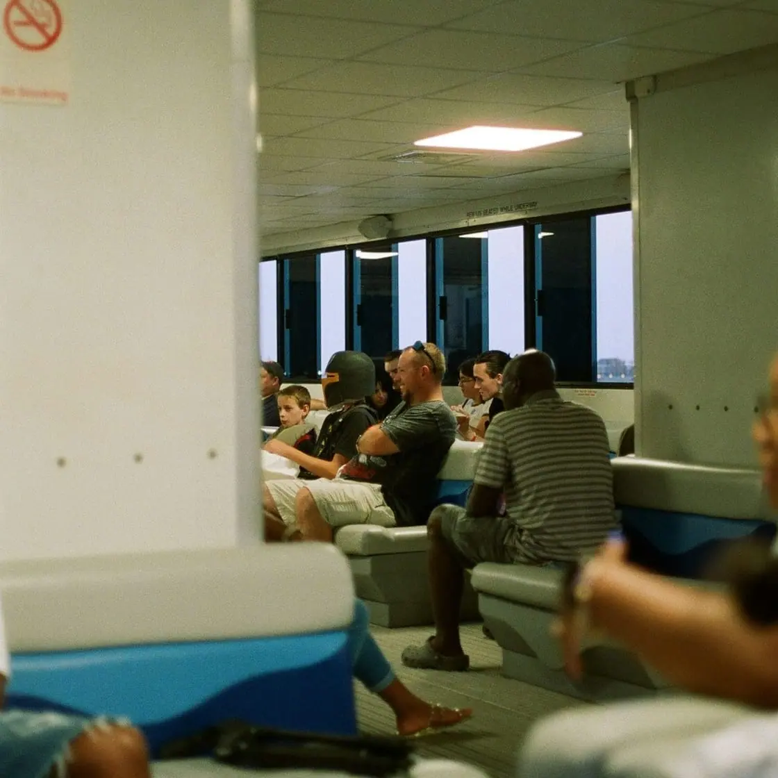 Sala de espera con asientos en fila y varias personas sentadas esperando su turno.